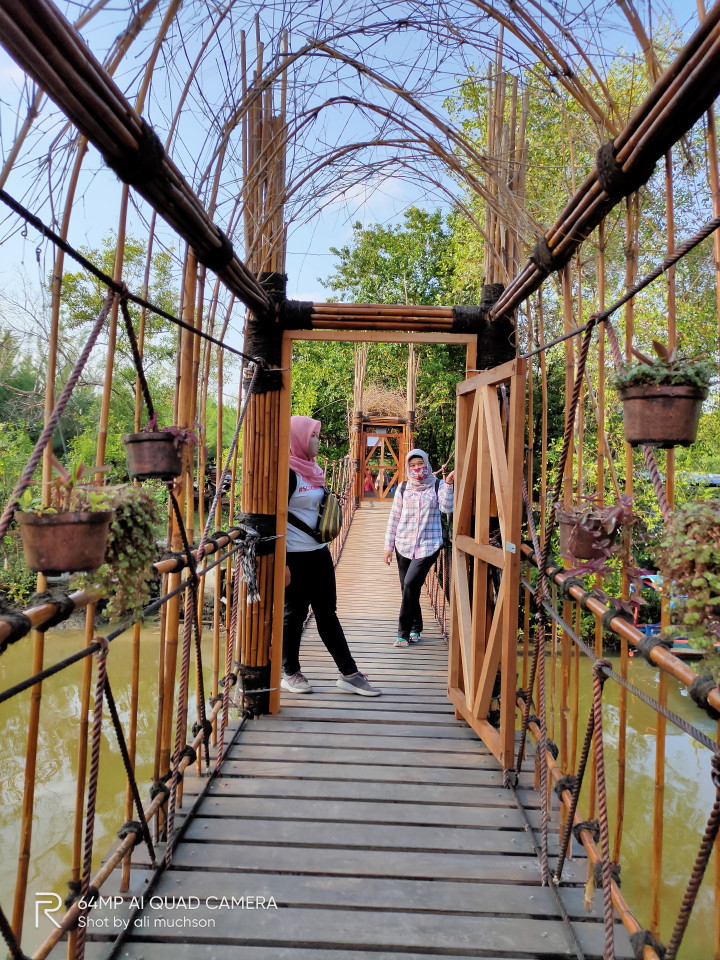 Jembatan bambu penghubung Ekowisata Mangrove Gunung Anyar Surabaya yang di sisi kiri dan kanan sungai.